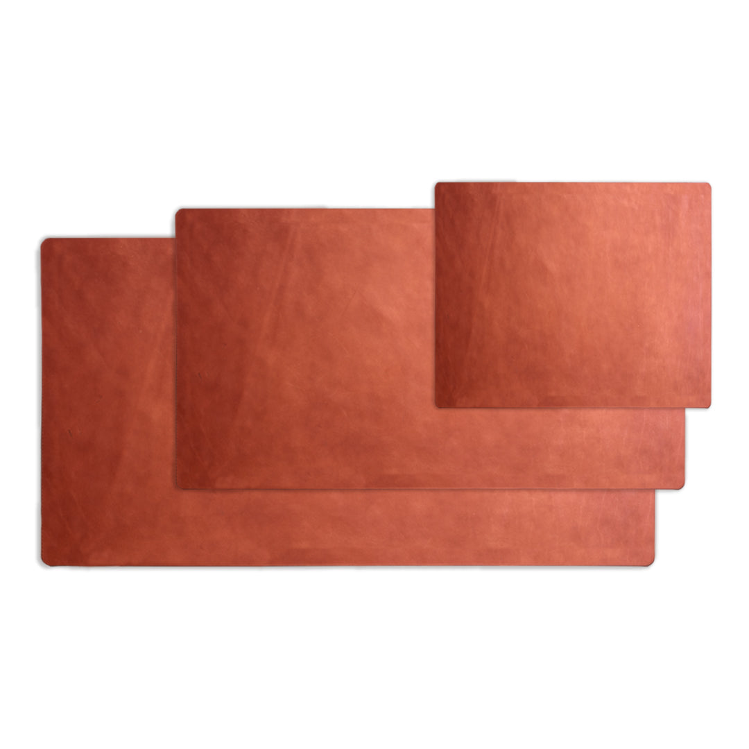 Three chocolate brown leather placemats on a white background